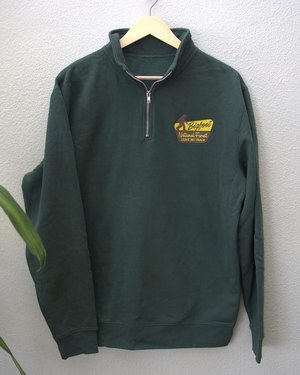 Dark green quarter-zip with the Bigfoot National Forest badge embroidered on the left chest